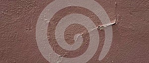 Weathered and peeling paint on wall. dark brown paint peeling on wall. old concrete wall has cracks and peeling, surface of cement