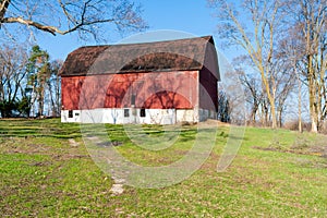 A weathered red barn on a hill