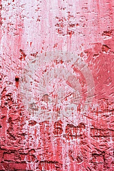 Weathered red plaster wall with paint dripping