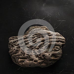 Weathered Rock On Dark Scratched Background. Legendary Artifact of Power, Courage and Healing Symbol Concept