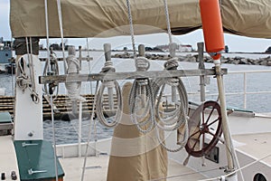 Weathered Ropes Tied to Wooden Pegs on a Sailboat