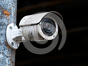 Weathered security camera mounted on a concrete wall