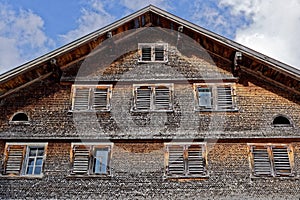 Weathered shingle house facade with window shutters