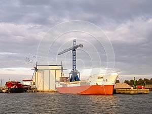 Weathered ship, crane, and crows in Lemmer harbor, Friesland, Netherlands