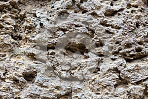 Weathered stone texture photo. Natural stone background. Porous rock relief. Old building stone wall