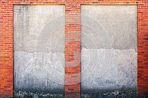 Weathered stucco wall and red brick frame around