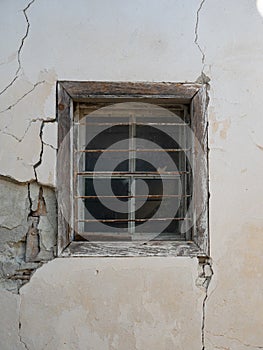 Weathered Window with Metal Bars in Crumbling Concrete Wall