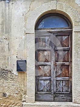 Weathered wood door with arch.