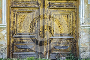 Weathered wood door with peeling yellow paint