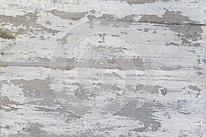 A Weathered wood texture with peeling white paint. Abstract grunge background.