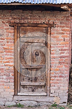 A weathered wooden door in a brick wall