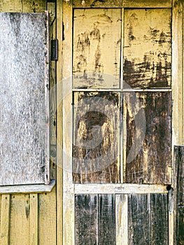 Weathered wooden door in legacy building with peeling old paint