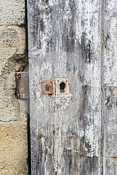 Weathered wooden door with white paint chipped and peeling.