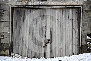 Weathered wooden doorway of an old concrete shed