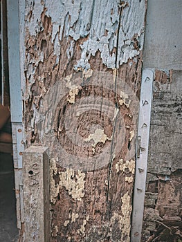 a weathered wooden post of a house painted blueq