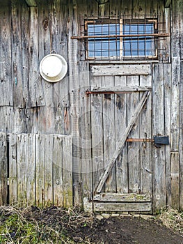 Weathered wooden shed wall with closed door and window