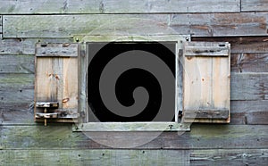 Weathered wooden wall with open window on colonial barn