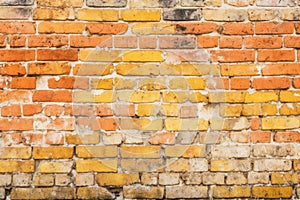 Weathered yellow and red brick wall, seamless pattern texture background.