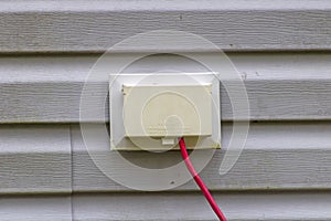 Weatherproof electrical outlet with cord plugged in