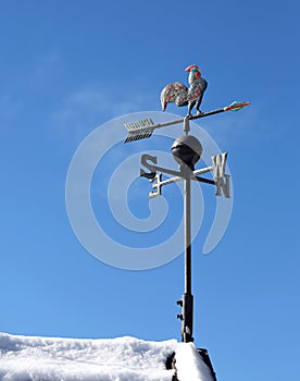 Weathervane and blue sky on the roof in winter