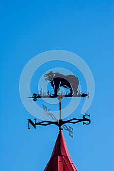 Weathervane in the form of a bear. Side of the world against the sky