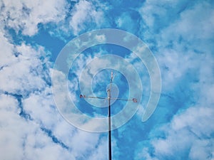 Weathervane under the culumus blue sky.