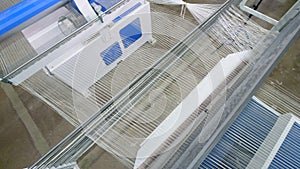 Weaving equipment looms strings of thins fiber at a textile plant.