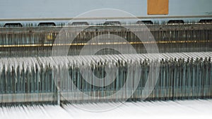 weaving looms. weaving factory. textile industry. Close-up. Automated weaving machine is fabricating cloth of threads