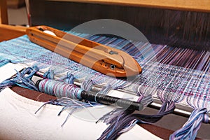 Weaving shuttle on the blue warp in weaving machine