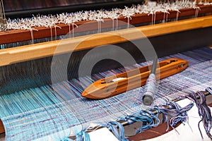 Weaving shuttle on the blue warp in weaving machine