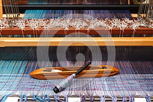 Weaving shuttle on the blue warp in weaving machine