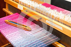 Weaving shuttle on the color warp in weaving machine