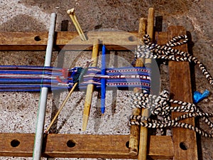 Weaving a wool sash, on a handloom