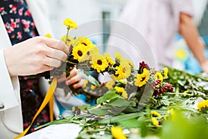 Weaving a wreath of wild flowers in a hand