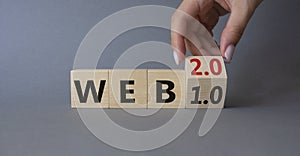 WEB 2 or 1 symbol. Businessman hand Turnes cube and changes word WEB 1.0 to WEB 2.0. Beautiful grey background. Business and WEB