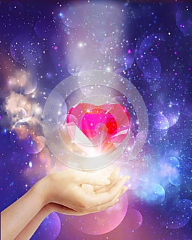 Cosmic love, universal diamond heart in hands with spark of hope, the light of faith