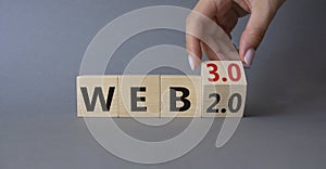 Web 3.0 vs Web 2.0 symbol. Hand turns cubes and changes the word web 2.0 to web 3.0. Beautiful grey background. Businessman hand.