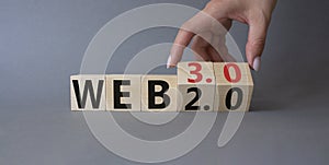Web 3.0 vs Web 2.0 symbol. Hand turns cubes and changes the word web 3.0 to web 2.0. Beautiful grey background. Businessman hand.