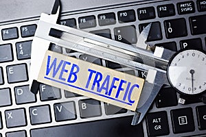 Web analytics concept, with caliper on laptop keyboard measuring online website traffic