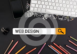 Web design concept. colorful pencils and a computer keyboard with a mobile phone on a black table