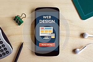 Web design concept on smart phone screen on wooden desk