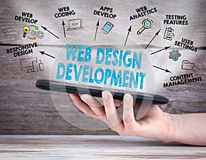 Web Design and Development concept. Tablet computer in the hand. Old wooden background
