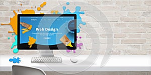 Web design studio concept with modern web site teme and web design text on computer display surrounded by color drops photo