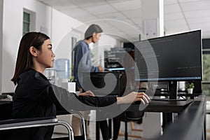 Web developer in wheelchair working on server coding in big data office