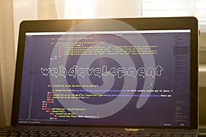Web developer workplace in sunset lights. Web development phrase ASCII art inside real HTML code