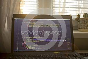 Web development phrase ASCII art inside HTML code. Web developer workplace in sunset lights