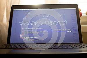 Web development phrase ASCII art inside HTML code. Web developer workplace in sunset lights