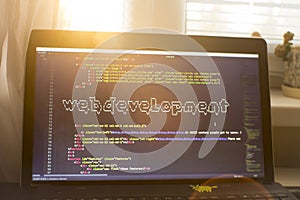 Web development phrase ASCII art inside HTML code. Web developer workplace in sunset lights