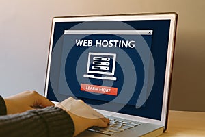 Web hosting concept on laptop computer screen on wooden table