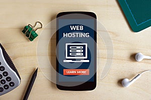 Web hosting concept on smart phone screen on wooden desk